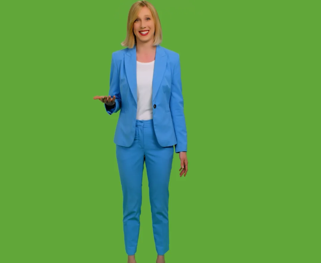 On-camera talent in a blue suit standing in front of the green-screen cyclorama in our Southington filming studio